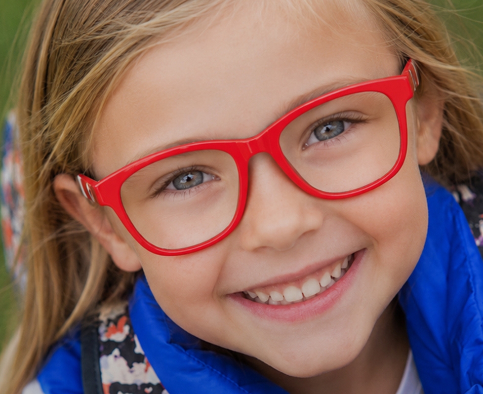 Enfant portant des lunettes de vue à monture rouge