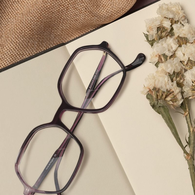 Monture Droit de Regard en acétate prune sur un carnet avec des fleurs séchées