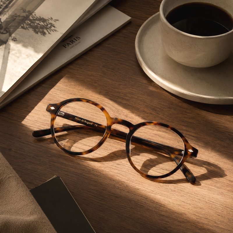 Monture ronde Droit de Regard en acétate écaille près d'une tasse de café